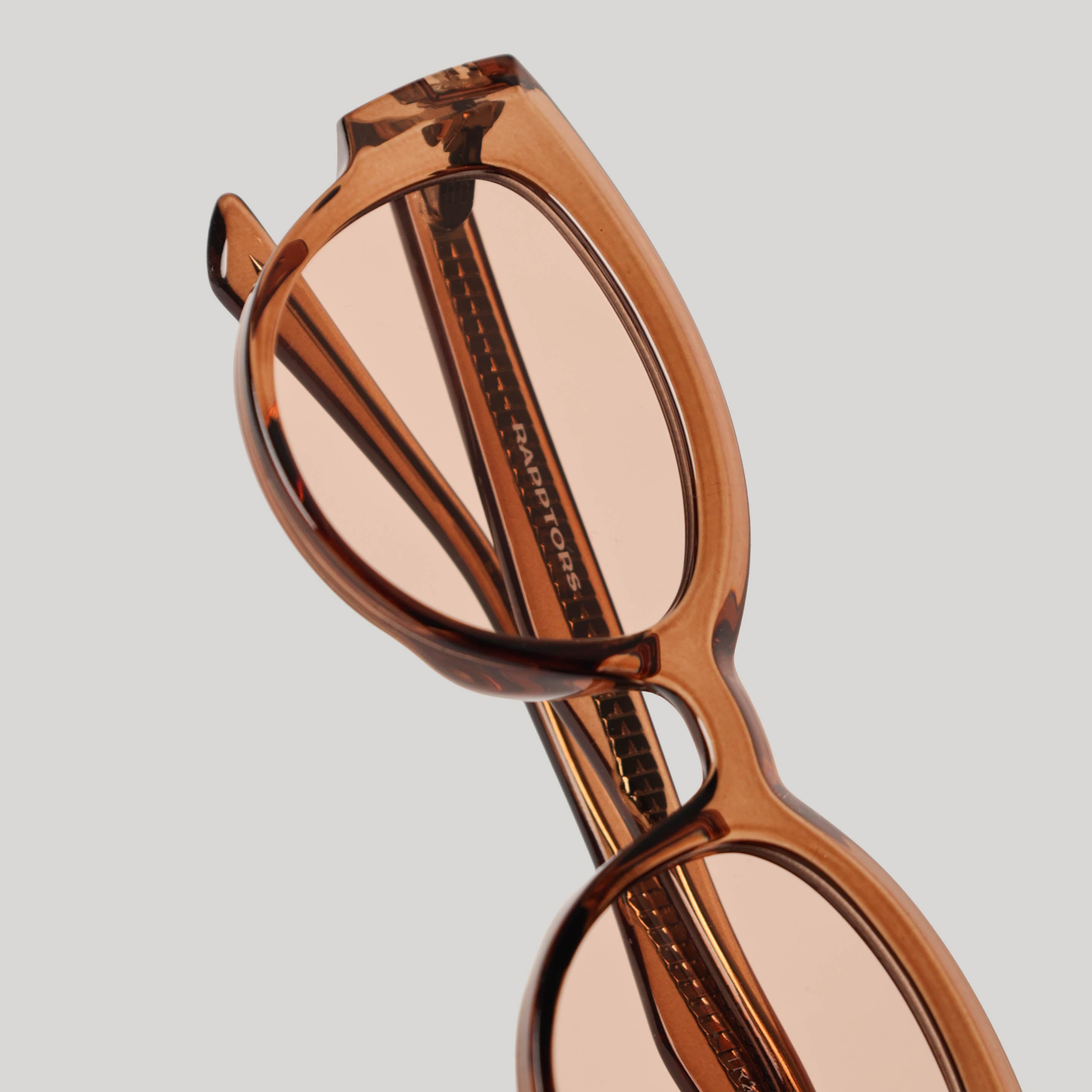 Brown sunglasses with a reflective surface on a light gray background