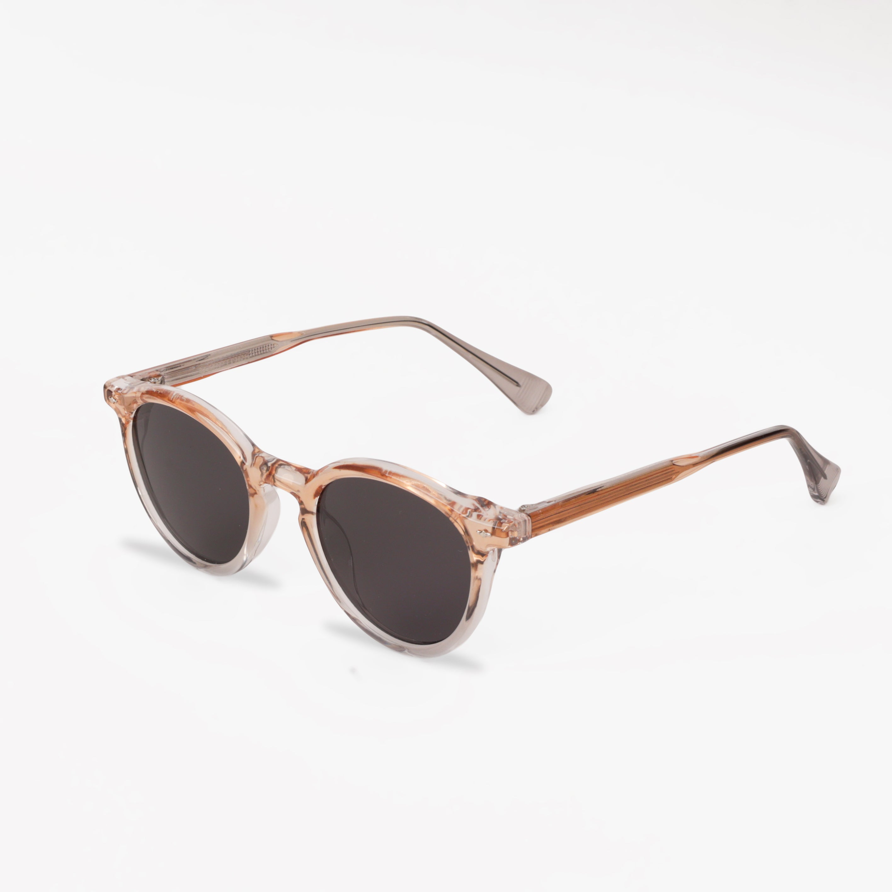 Sunglasses with a rose gold frame and dark lenses on a white background