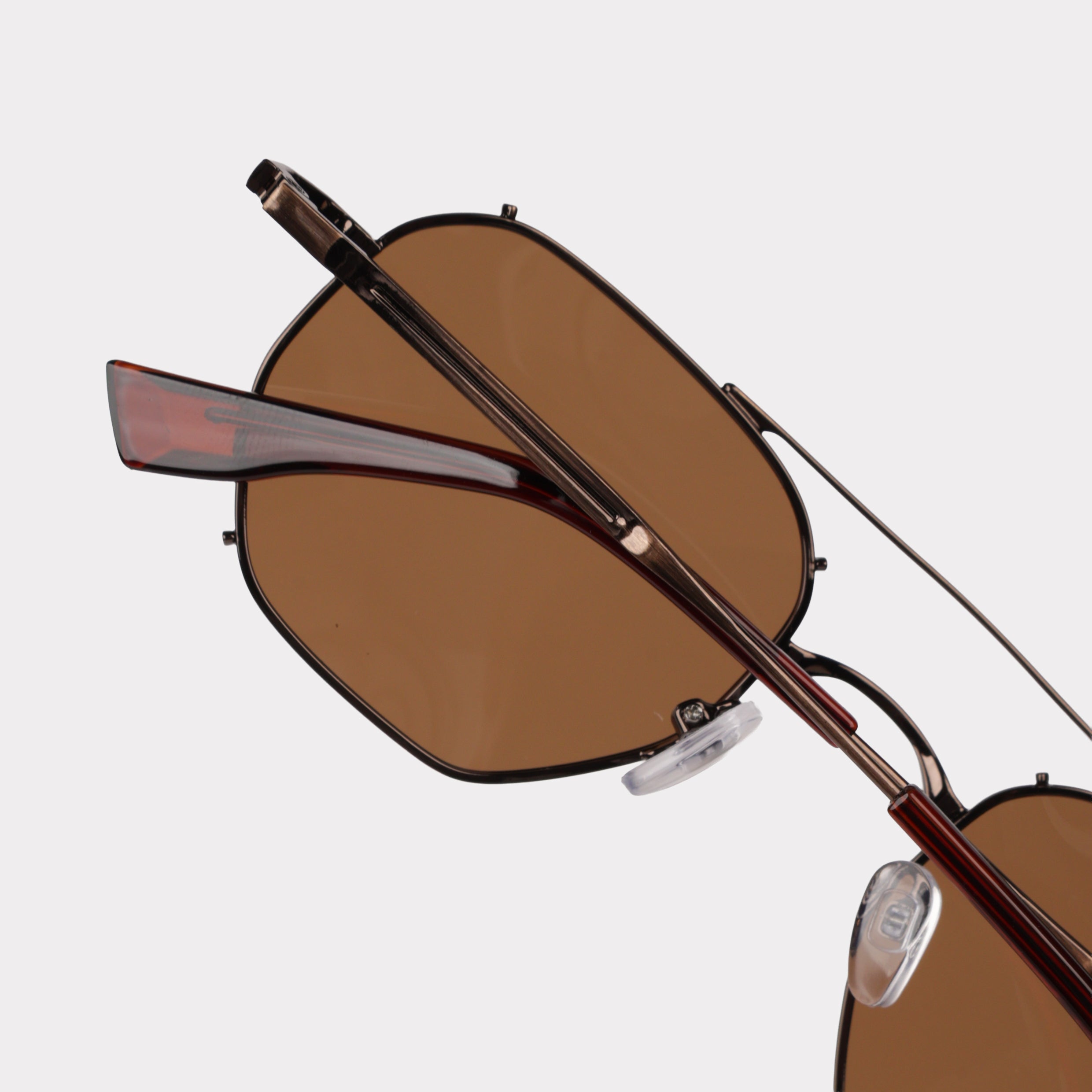 Brown sunglasses with a reflective lens on a light gray background