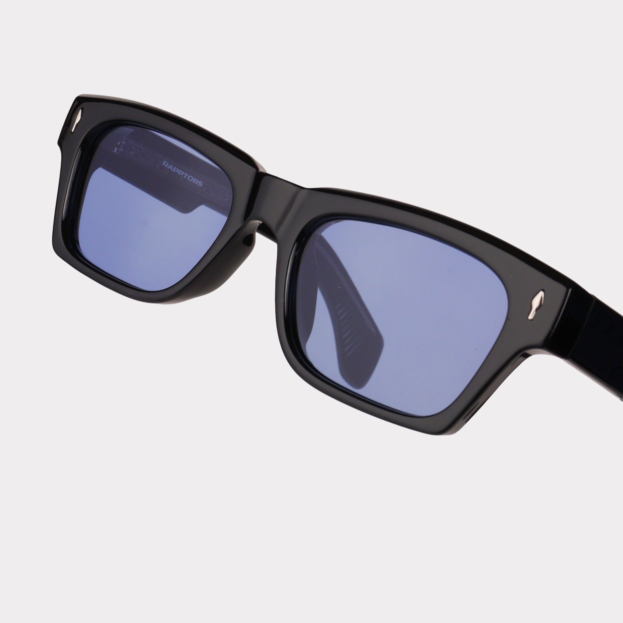 Black sunglasses with blue lenses on a light gray background