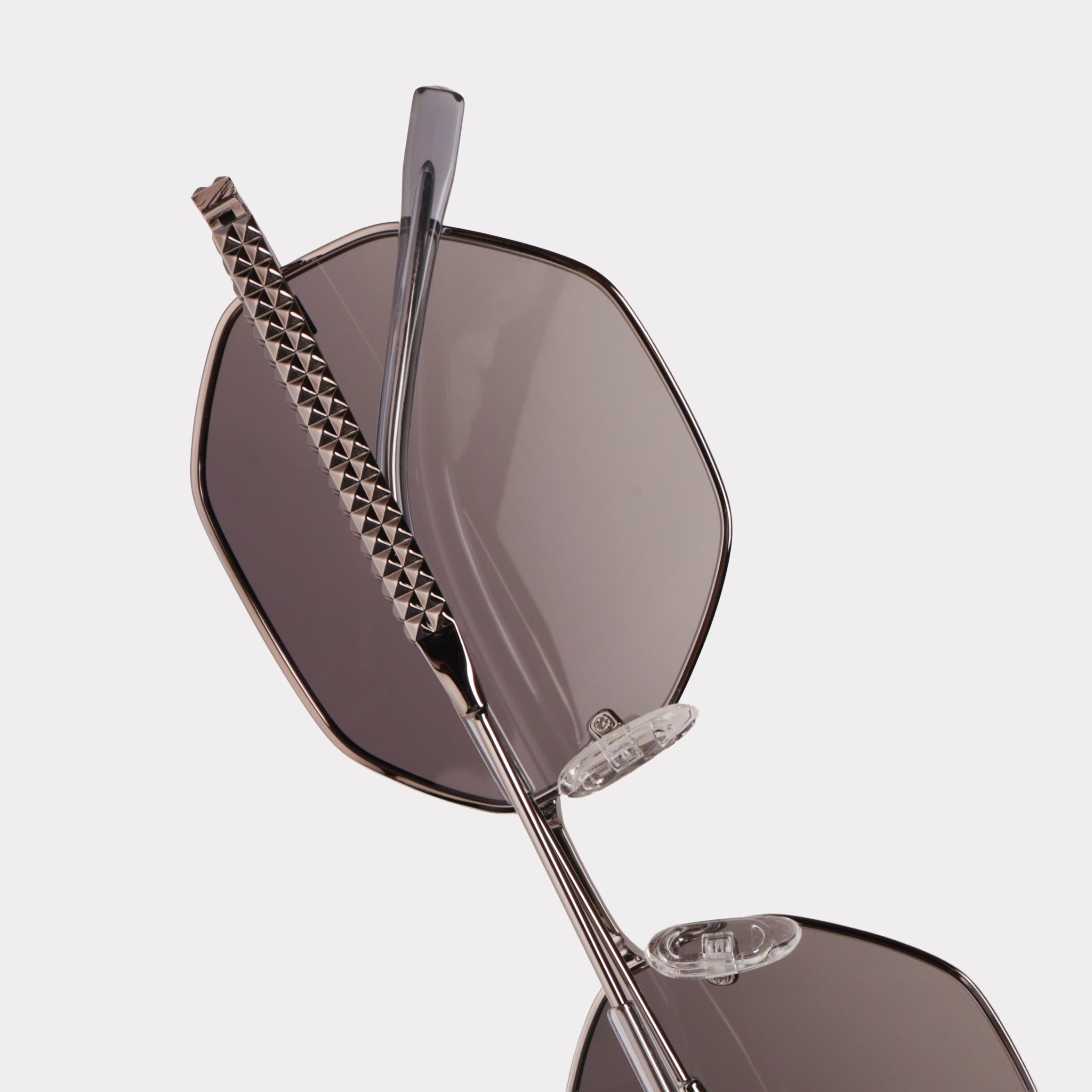 Sunglasses with a chain detail on a light gray background