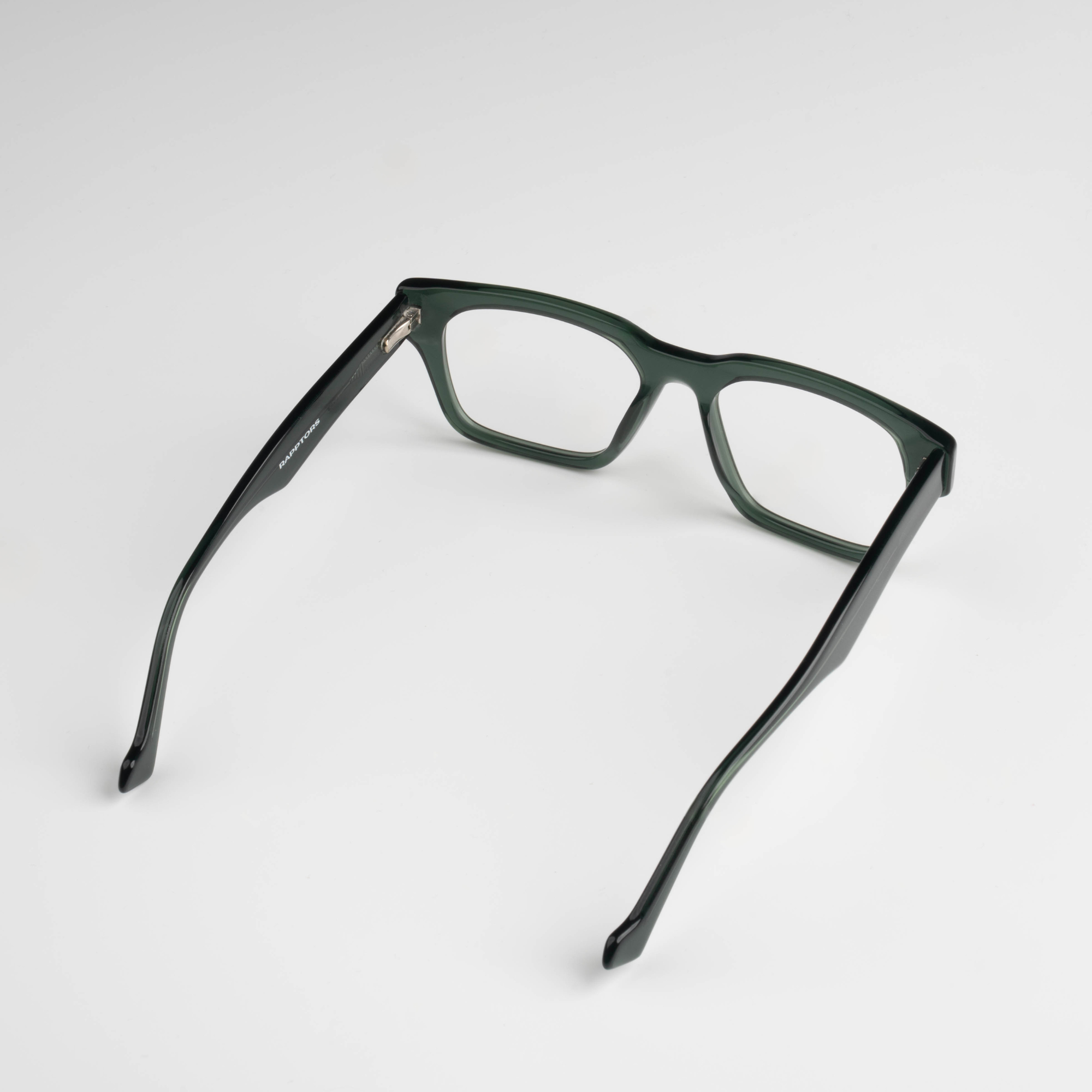 Green eyeglasses on a light gray background